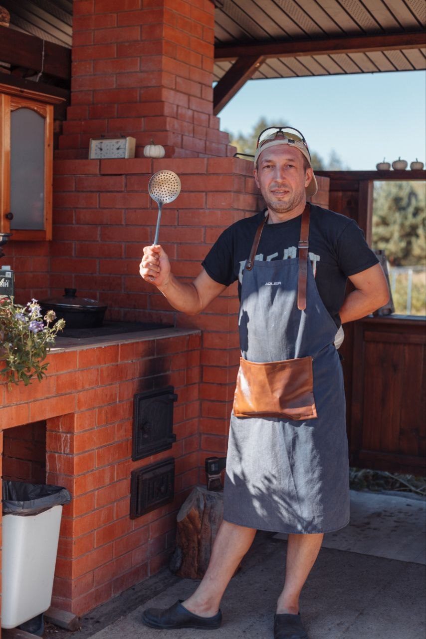 Повар у кирпичной печи летней кухни усадьбы